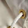 Detail of white cotton rope and brass grommet in tough canvas ditty bag. Elegant vintage design details.