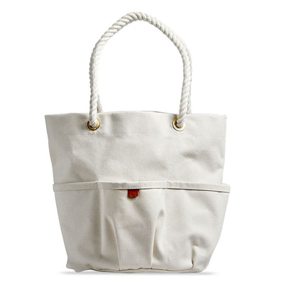 Front of a handcrafted, heirloom-quality bucket bag. Durable off-white canvas, cotton rope, bass grommets and outer pockets.