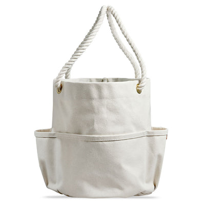Back of a handcrafted, heirloom-quality bucket bag. Durable off-white canvas, cotton rope, bass grommets and outer pockets.