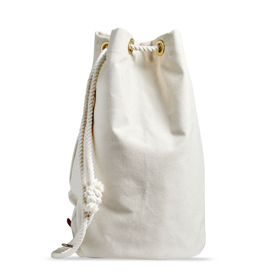 Ditty bag of tough, off-white canvas. Elegant vintage cylindrical design, white cotton rope woven through brass grommets to cinch shut. 