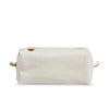 Side view of Dopp kit made from sturdy off-white canvas with metal zipper and leather detail. Classic small travel and toiletry bag. 